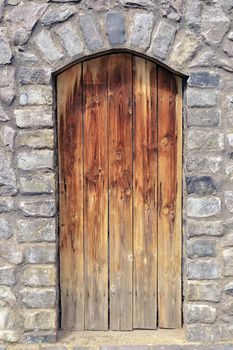 old time wooden door in medieval stone wall