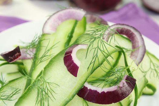 Cucumber salad with red onions and dill on a plate