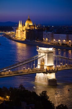 Budapest cityscape sunset with Chain Bridge in front over Danube river and with Parliament Building in the background.