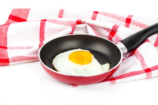 Fried egg in a frying pan, over white background