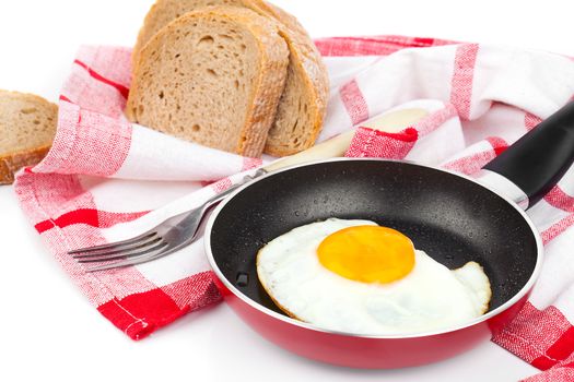 Fried egg in a frying pan, over white background