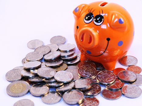 Bunch of Latvian lat coins and piggy bank on white background