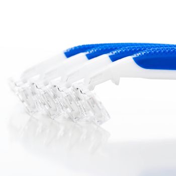 Picture of a few white and blue razors for men over a white background