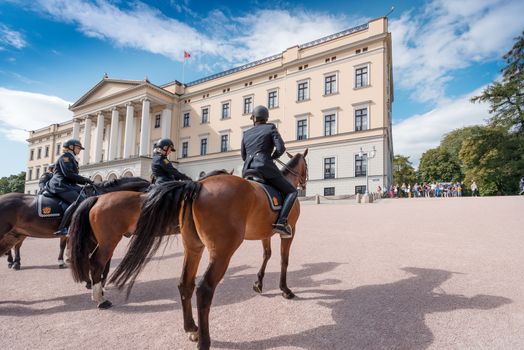 OSLO, NORWAY - AUGUST 28: Mounted Police near Oslo Royal Palace at August 28, 2014. Rytterkorpset (The Mounted Police) established at 1893. At present 15 horses and around 25 officers.