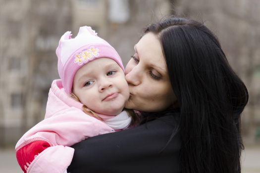 Little girl keeps mum on his hands. The girl thoughtfully laid her head on her mother's shoulder. A warm spring day.
