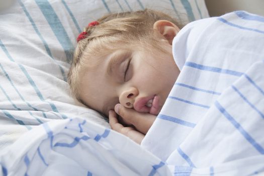 A child of four years old sleeps in a parlor car trains. Portrait