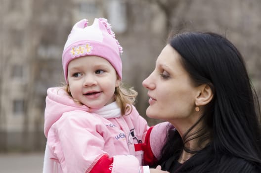 Little girl keeps mum on his hands. The girl thoughtfully laid her head on her mother's shoulder. A warm spring day.