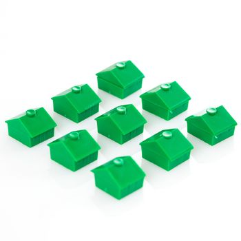 Many green toy houses over a white background