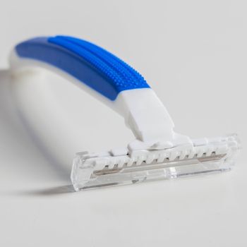 Picture of white and blue razor for men over a white background