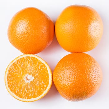 Some sliced and whole oranges together over a white background