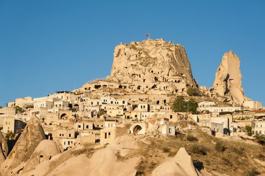 Ancient town and a castle of Uchisar dug from a mountains after sunrise, Cappadocia, Turkey