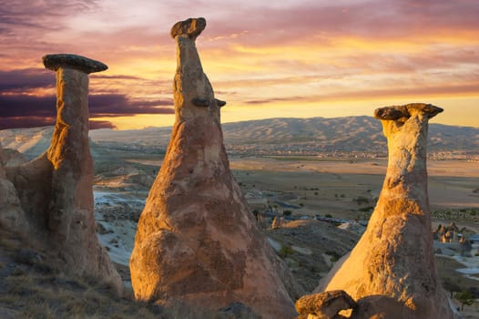 Rocks looking like mushrooms dramatically lit by a sunset in Cappadocia, Turkey