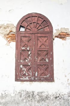Old ancient brown window in vintage style on damage wall.