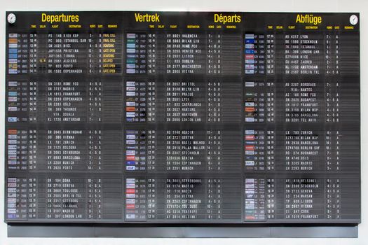 Airport departure board in terminal with flight information