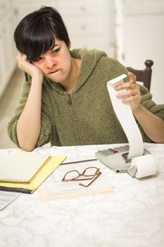 Multi-ethnic Young Woman Agonizing Over Financial Calculations in Her Kitchen.