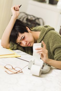 Multi-ethnic Young Woman Agonizing Over Financial Calculations in Her Kitchen.