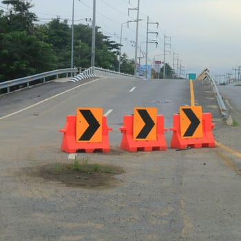 Many traffic sign on the road near the bridge.