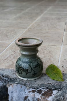 The green joss stick pot put on the floor.It is painting by patterns of folk art.