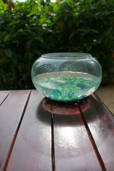 There are marble glasses in the fishbowl on the corner of table.