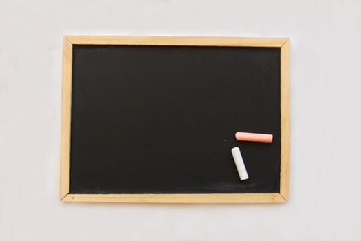 Small blackboard and chalks for writing or drawing.