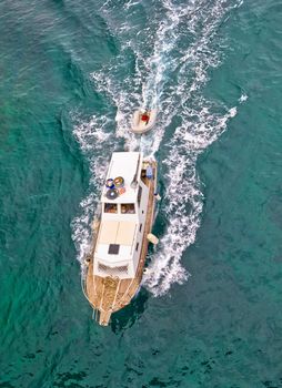 Fishing trawler on blue sea aerial vertical view