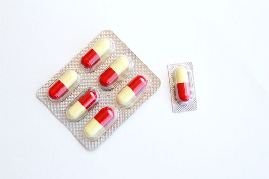 Many capsules in the plastic package.They have red and yellow color.