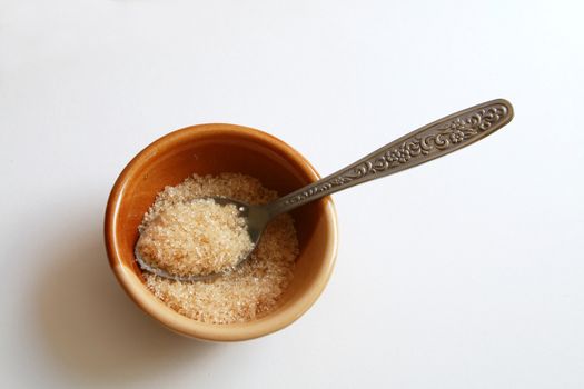 Brown sugar in the bowl and tea spoon.