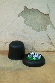 Dice set on the floor and cracked wall behind.