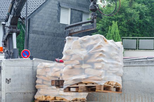 Pallets with sandstones are delivered and unloaded from a truck.