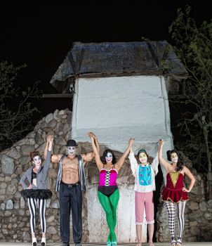 Group of celebrating cirque performers on stage