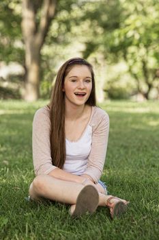 Laughing teen girl with braces sitting outside