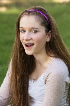 Single laughing teenage female with braces on teeth