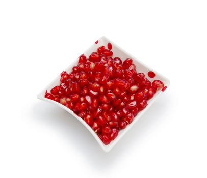 Loose pomegranate seeds in a white bowl 