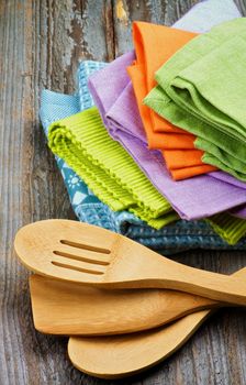 Arrangement of Multi Colored Cloth Napkins and Kitchen Spoons isolated on Rustic Wooden background