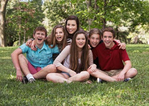 Cute group of six teens outdoors laughing