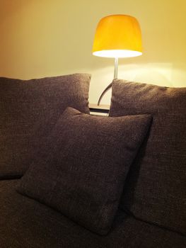 Cozy orange lamp and comfortable sofa in the living room.