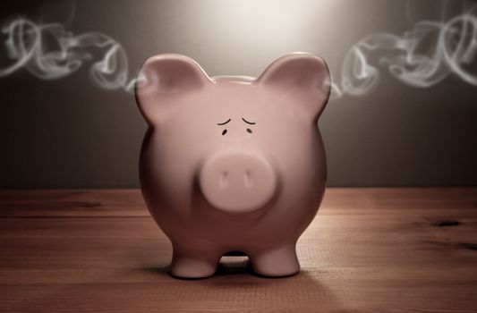 Piggy bank with smoke coming out of its ears