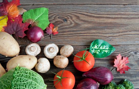 Autumn fruits and vegetables over rustic wood