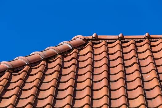 Red roof tile pattern over blue sky