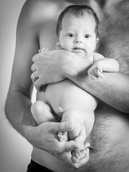 Black and white photo of a father holding his baby girl