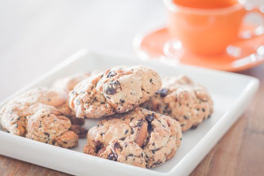 Closeup mixed nut cookies with mini orange coffee cup, stock photo