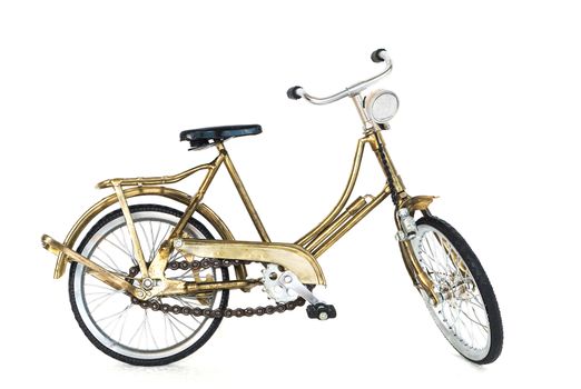 Small gold color toy bicycle on white background