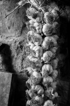 Picture of many plaited garlic in a rustic context.