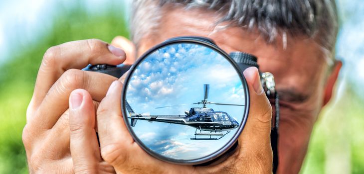 Photographer taking photo with DSLR camera at Helicopter. Shallow DOF