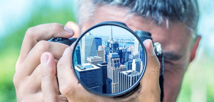 Photographer taking photo with DSLR camera at Manhattan skyline. Shallow DOF