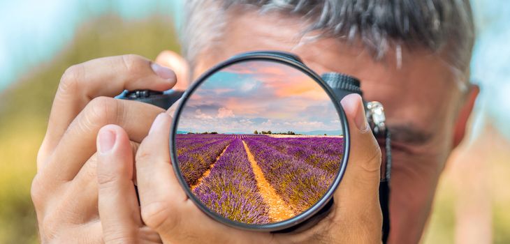 Photographer taking photo with DSLR camera at lavender fields. Shallow DOF..
