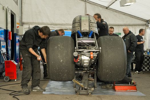 Santa Pod, UK - October 29, 2011: Mechanics working on a dragster at the Flame and Thunder event at Santa Pod Raceway in Northamptonshire, UK