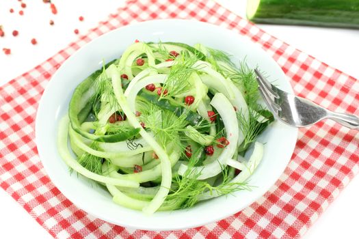 Spaghetti cucumber with red pepper and onions on bright background