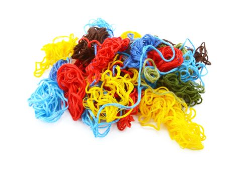 Multi-coloured embroidery threads in a tangled heap, isolated on a white background
