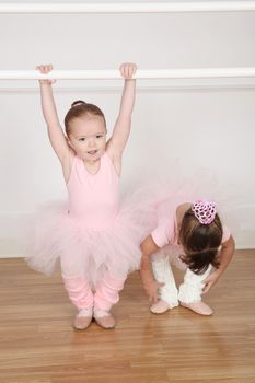 Beautiful little ballet dancers at the dance studio barre 